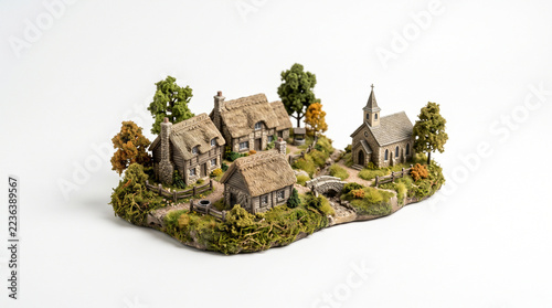 A detailed miniature model of a quaint rural village with miniature diorama depicting small hamlet thatched roof cottages stone church grassy base craftsmanship