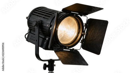 Fotografie Professional black Fresnel spotlight with barn doors emitting warm light, isolat