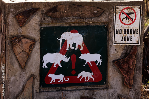 Wildlife warning sign for dangerous wildlife and drone prohibition at an unfenced picnic site in Ithala Game Reserve, South Africa 17491