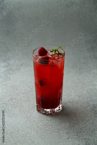 Obraz na plátně Refreshing raspberry drink served in a tall glass, adorned with mint and ice, wa