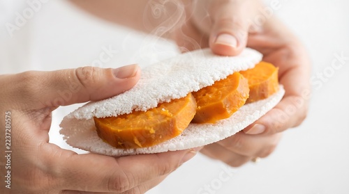 Hands holding freshly made powdered sugar filled pastry with fruit filling