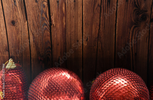 Red  Christmas balls with shiny sequins on a wood table. Festive holiday decor.