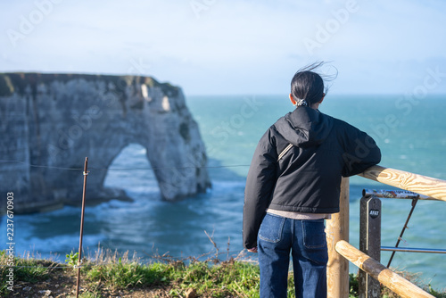 Touriste contemplant les falaises et l’arche naturelle d’Étretat en Normandie