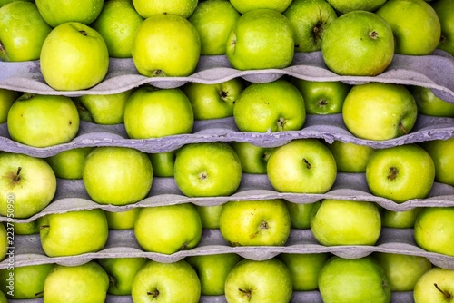 Fresh green Granny Smith apples at market, full frame background pattern.