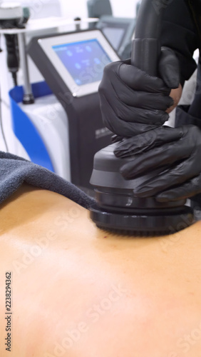 Professional body shaping therapy with vibromassage thermo vacuum and bioelectrical stimulation in beauty salon. 