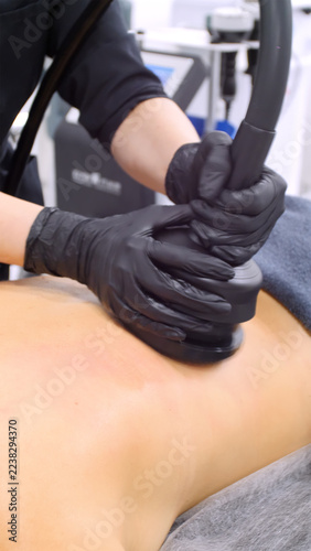 Professional body shaping therapy with vibromassage thermo vacuum and bioelectrical stimulation in beauty salon. 